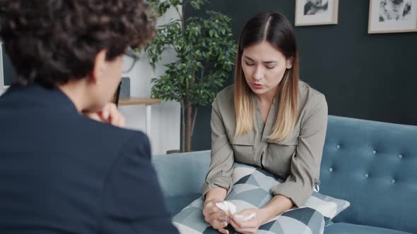 Depressed Girl Crying and Speaking During Therapy Session with Psychologist alt