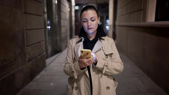 Busy Woman Walking with Smartphone on City Street alt