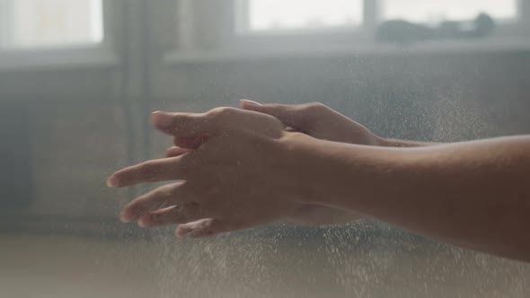 Woman Rubbing Hands With Chalk Powder At Workout alt
