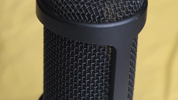 Studio Condenser Microphone Rotates on Yellow Background with Place for Text alt