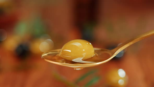 Olive Oil Green Oilve on Brown Background Closeup alt