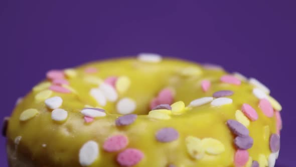 Donut with White Icing on a Lilac Background