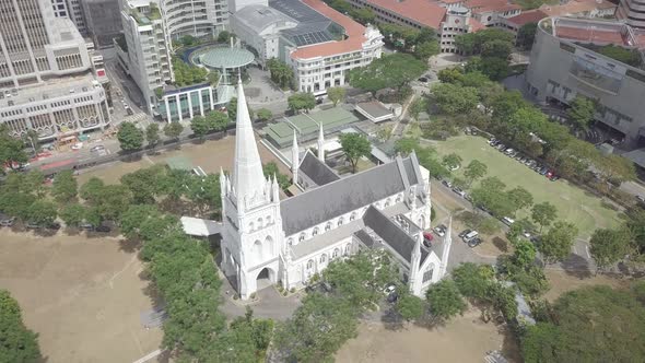 Aerial view Gothic Church in Singapore, green grass, trees and high buildings near the church