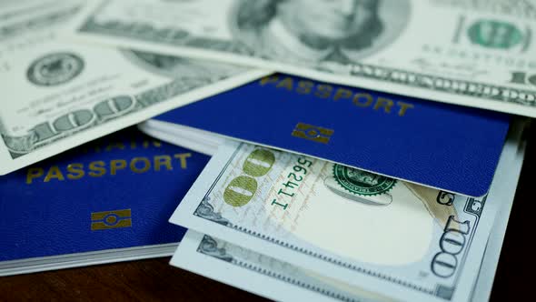 Dollar Bills and Blue ID Passports on Wooden Background