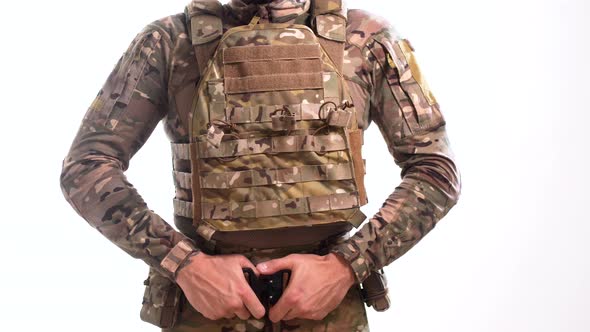 Special operations officer in multicam camouflage and plate carrier puts on a war belt