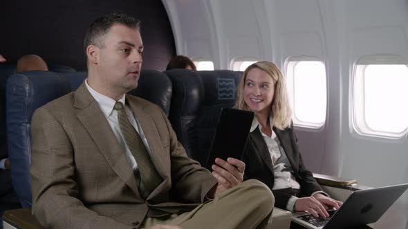 Flight attendant talking to passengers on airplane