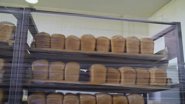 Bread on Shelves Under Cling Film. Freshly Baked Bread Trays in a Row. The Bread Is Stored in a alt