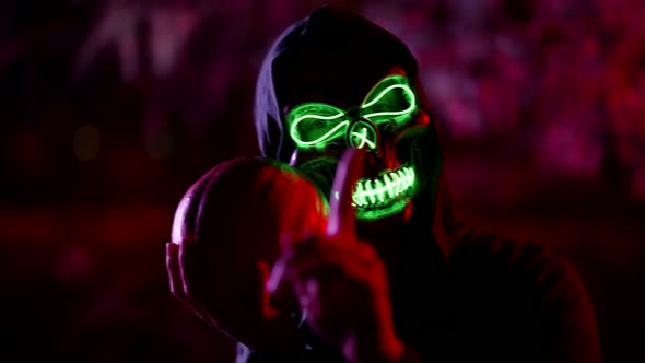 Dangerous Mystical Ghost with Glowing Skull is Holding Pumpkin and Wagging Finger to Camera alt