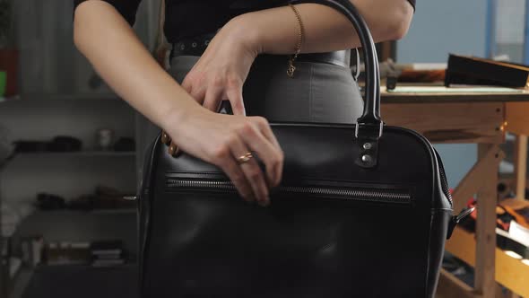 Girl in a Business Suit in the Workshop for Production of Leather Goods Demonstrates Black Women's alt