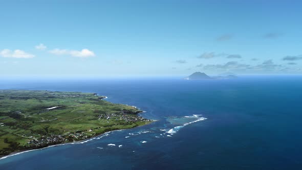 Aerial footage of settlements, the sea and the shadow of a mountain in Saint Kitts and Nevis alt