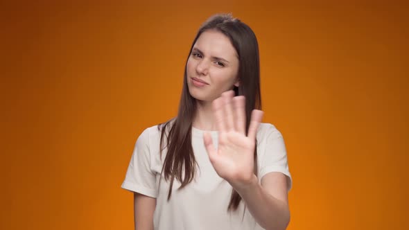 Displeased Young Woman Covering Eyes and Gesturing Stop Against Yellow Background alt