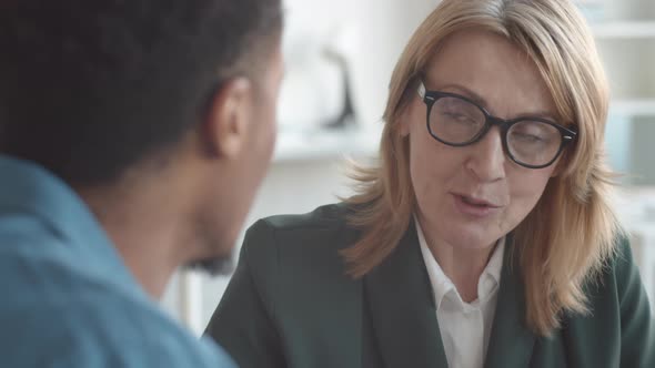 Female HR Director Talking to Black Employee at Appraisal Meeting in Office alt