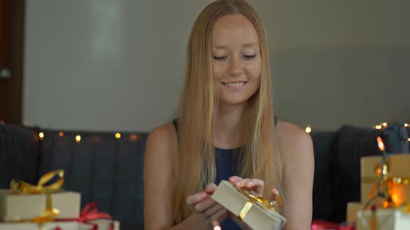 A Young Woman Packing Presents. Present Wrapped in Craft Paper with a Red and Gold Ribbon for alt