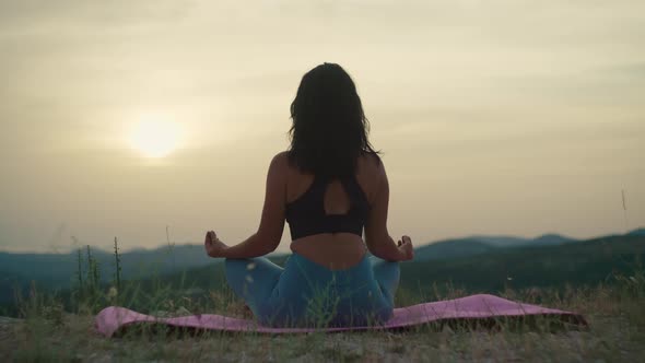A Girl on Top of a Mountain Practices Yoga and Meditates Alone alt