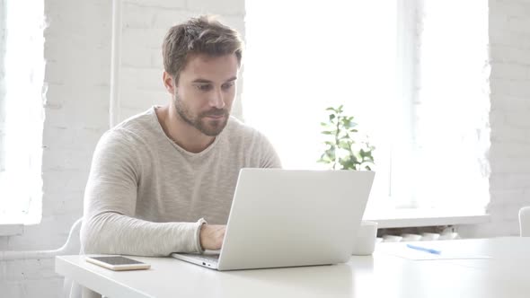 Businessman Leaving Office After Closing Laptop at Work alt