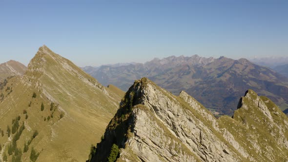 Fast aerial orbit around summit with cross on top. The Alps in the background and autumn colors alt
