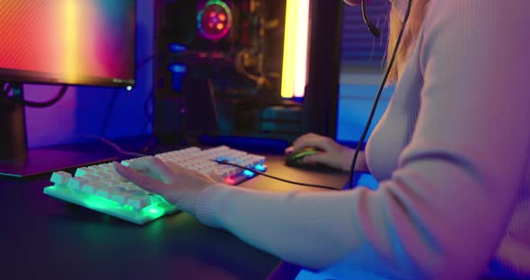 Close up gamer hands actively pushing buttons with colorful neon LED lights alt