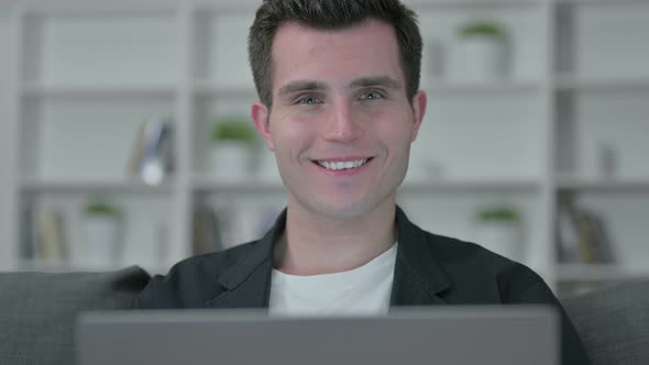 Portrait of Young Male Designer with Laptop Smiling at Camera alt