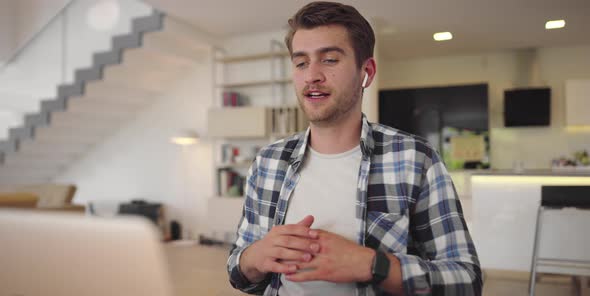 Smiling Businessman Wear Wireless Headset Making Conference Video Call on Laptop alt