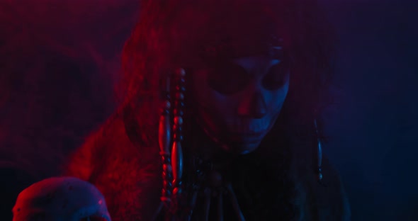 Close Up of a Tribal Shaman Conjuring with a Cane in the Smoke and Red Light,  alt