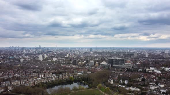 Wide panoramic aerial shot panning left over London cityscape on overcast cloudy day alt