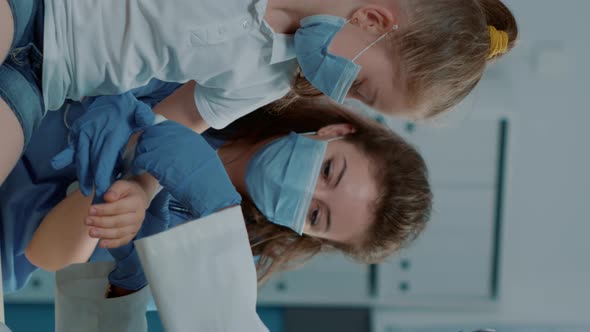 Vertical Video Diverse Medical Team Applying Bandaid on Child with Fractured Arm alt