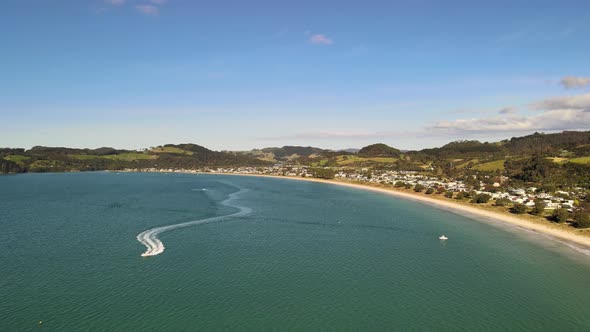 Power boat on a summers day cruising through the waters of Coromandel in Cooks bay - Drone flight ba alt