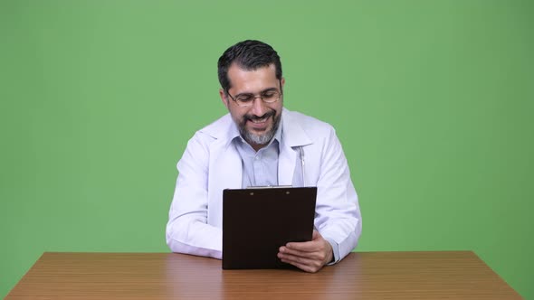 Handsome Persian Bearded Man Doctor Reading Clipboard