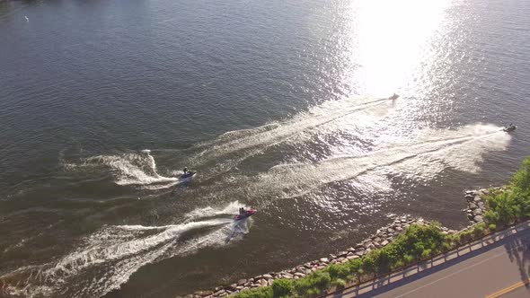 Four Jet-skis racing on a Minnesota lake in the summertime from a drone alt