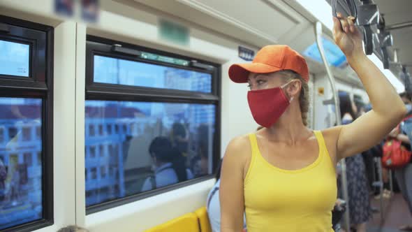 Woman Travel Caucasian Ride Overground Train Airtrain Wearing Protective Medical Mask alt