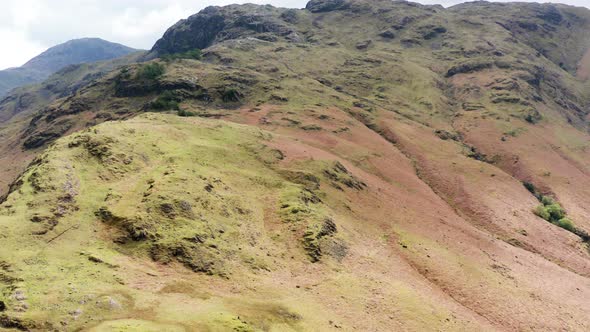 Aerial View Over Hills Towards Mountains