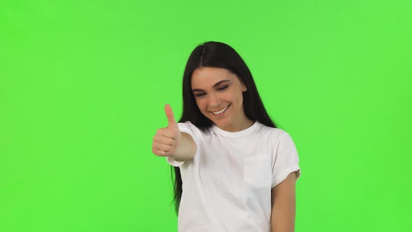 Happy Beautiful Woman Showing Thumbs Up on Green Background alt