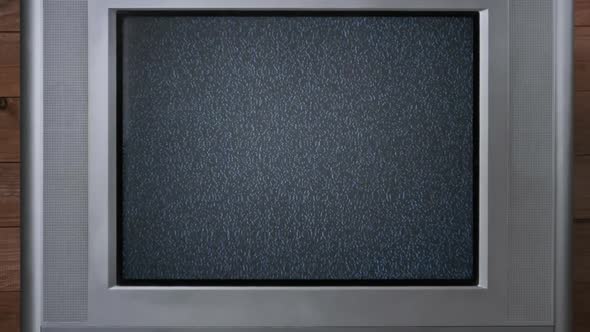 Static Noise on Screen of an Old CRT TV on Wooden Backdrop No Signal Zoom Out alt