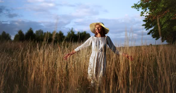 Happy Woman Walking on Field Sunset