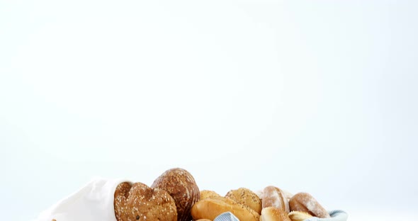 Various bread loaves on wooden table alt
