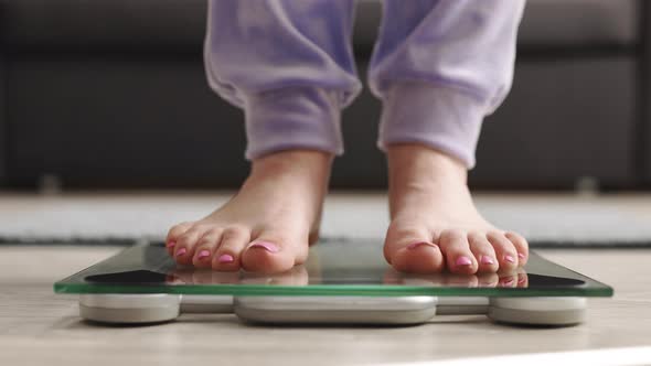 Person Steps on the Digital Scales to Check Her Weight