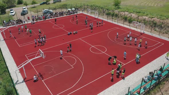 Aerial View of Young Athletes Playing Basketball on an Open Public Basketball Court alt