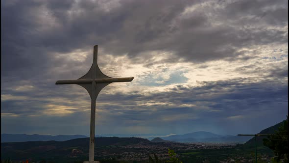 Timelapse christian cross at sunrise with clouds landscape horizon in the sky far away in the city alt