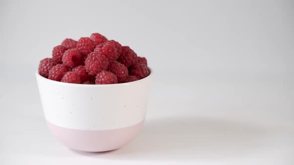 Plate with Delicious Fragrant Raspberries on a White Background