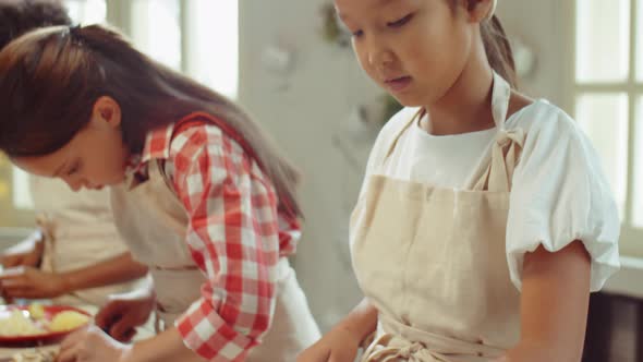 Asian Girl Cutting Champignon on Culinary Lesson alt