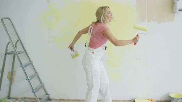 Relaxed Woman Dancing with Paint Roller alt
