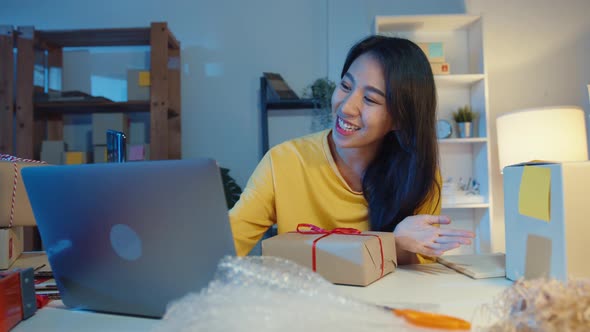 Young Asia businesswoman use smartphone receive purchase order and show product packaging. alt