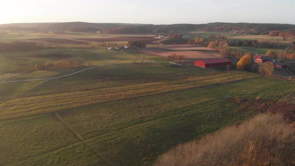 Red Barn and Farm Field at Sunset Aerial Forward
