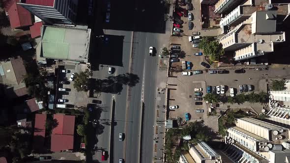 Amazing aerial look down view over roof tops of high buildings to car road traffic in largest city i alt