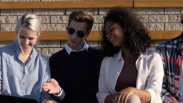 Student group outdoors laughing spending time together. alt