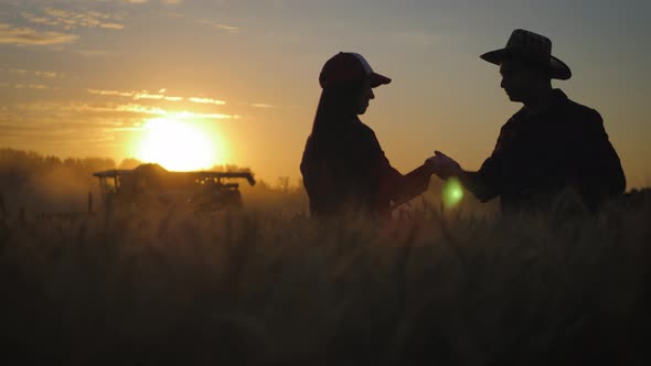 Farmers Handshake Over the Wheat Crop in Harvest Time. Team Farmers Stand in a Wheat Field with alt