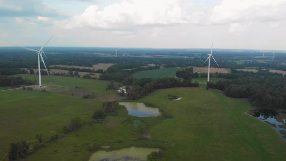 Aerial view of rural area with fields, wind turbines and ponds.