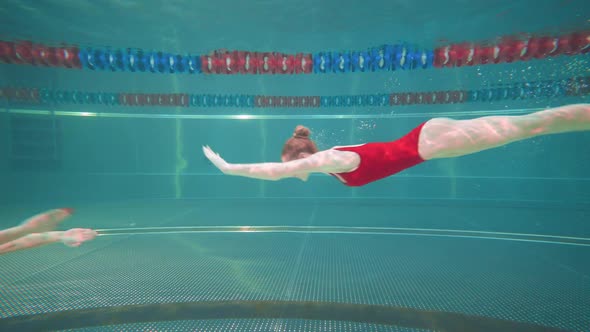 Professional Females Swimmers in the Pool Young Womans Perform the Elements of Synchronized Swimming alt