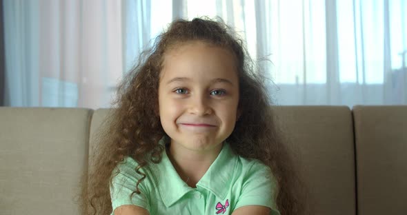 Portrait Honey Little Girl Smiling Child Looking at Camera are Sitting on the Couch at Home Cute Kid alt