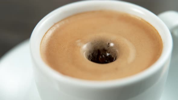 Drop Falling Into a Cup of Coffee in Super Slowmotion. alt